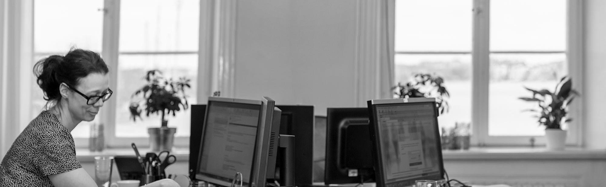 En receptionist sitter framför en dator